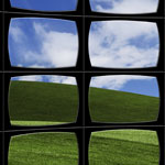 A grid of vintage television screens displaying segmented views of a green grassy hill under a blue sky with white clouds.